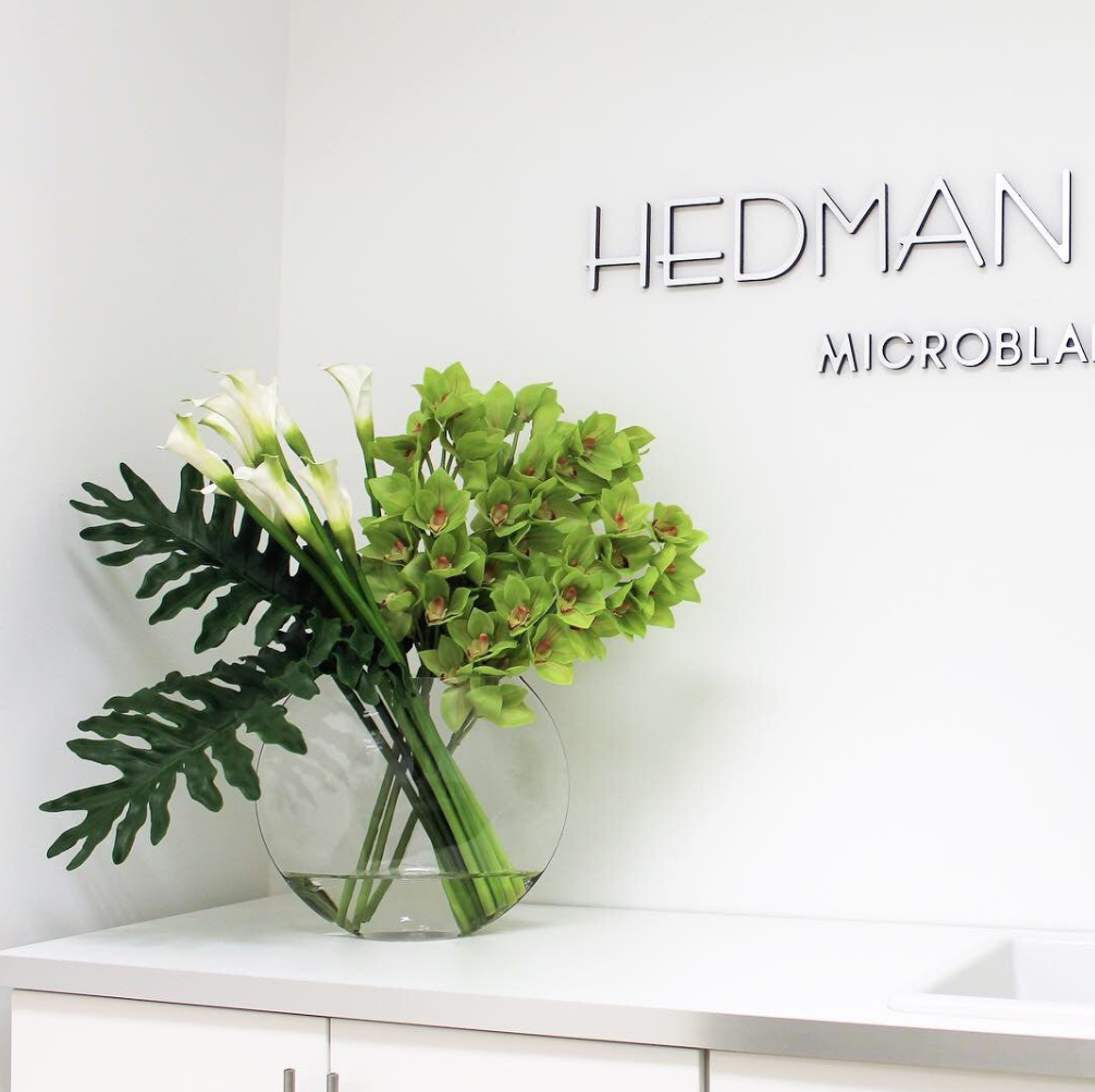 lunar jarrón con verde cymbidium orquídeas y cala lirios.