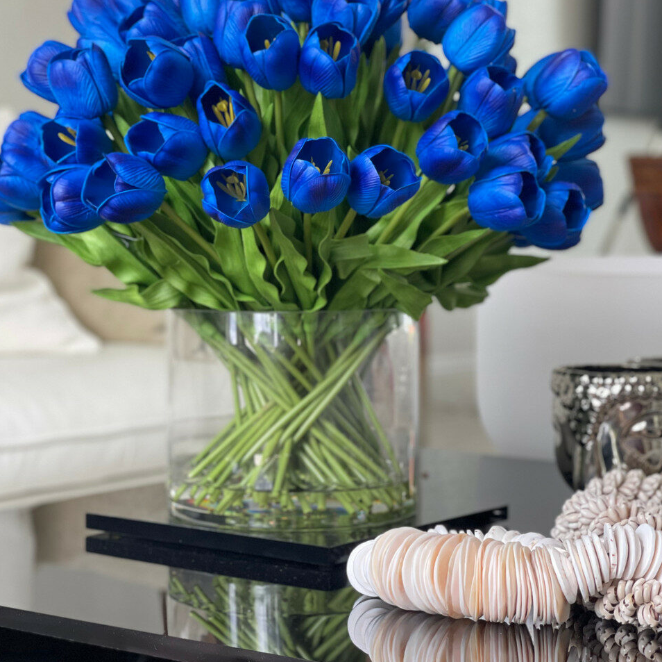 azul tulipán arreglo en un grande Cylindrical jarrón