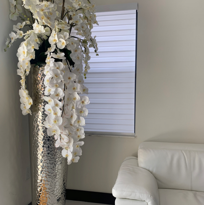 cascada phalaenopsis orquídeas en un extra-alto jarrón con un hammered finish.