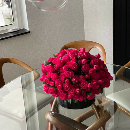 oscuro rosa inglés rosas en un negro vidrio jarrón.