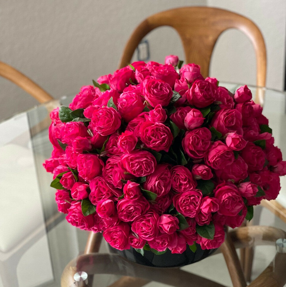 oscuro rosa inglés rosas en un negro vidrio jarrón.