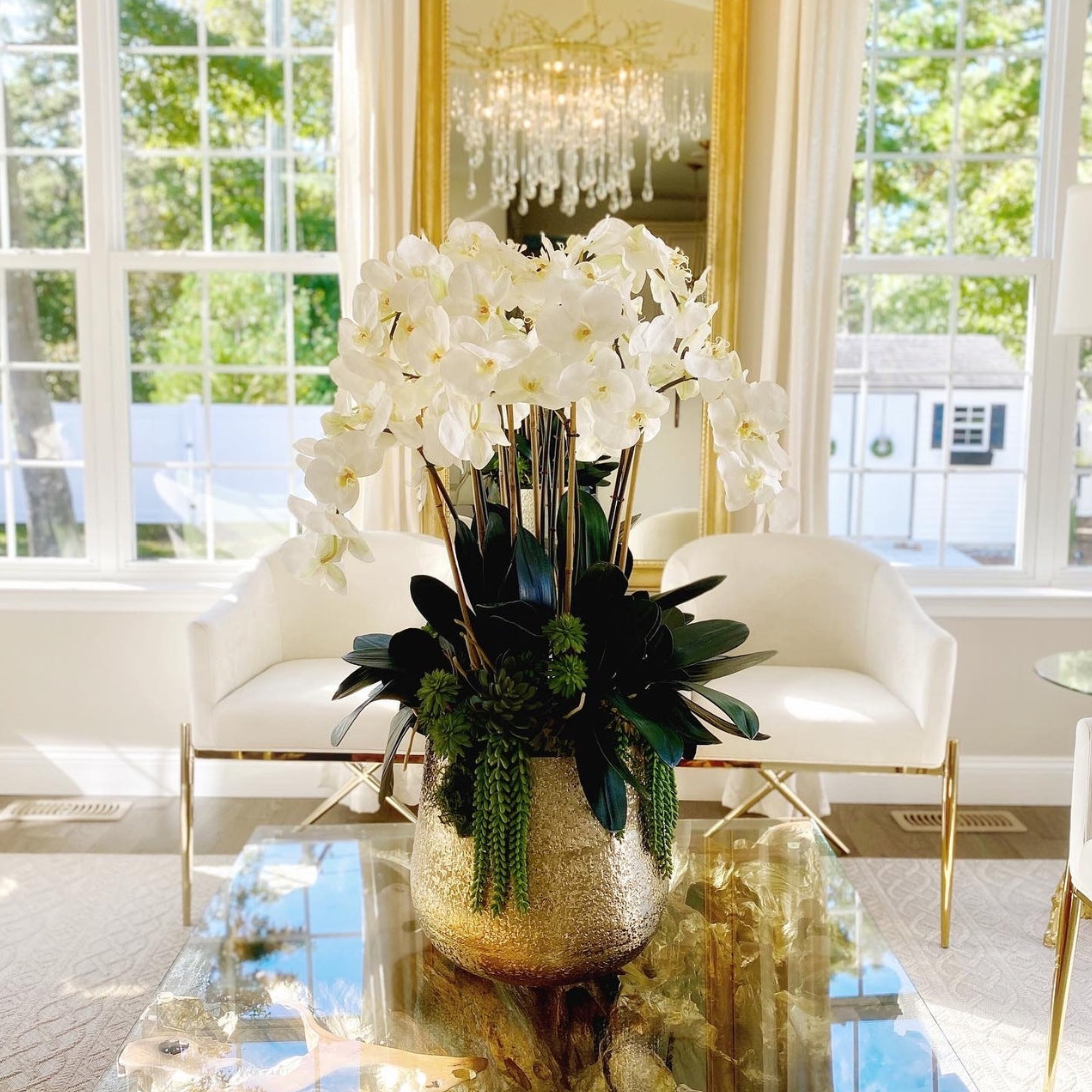 delaney dorado jarrón con múltiples stems de phalaenopsis orquídeas y succulents.