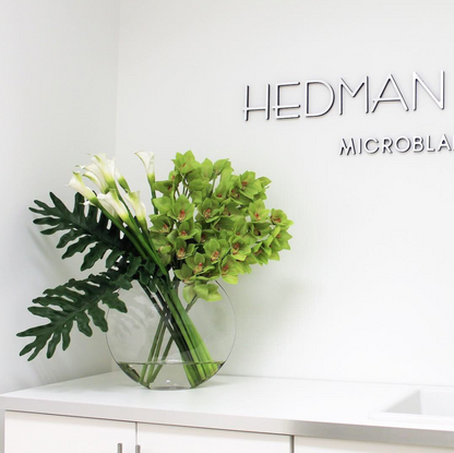 lunar jarrón con verde cymbidium orquídeas y cala lirios.