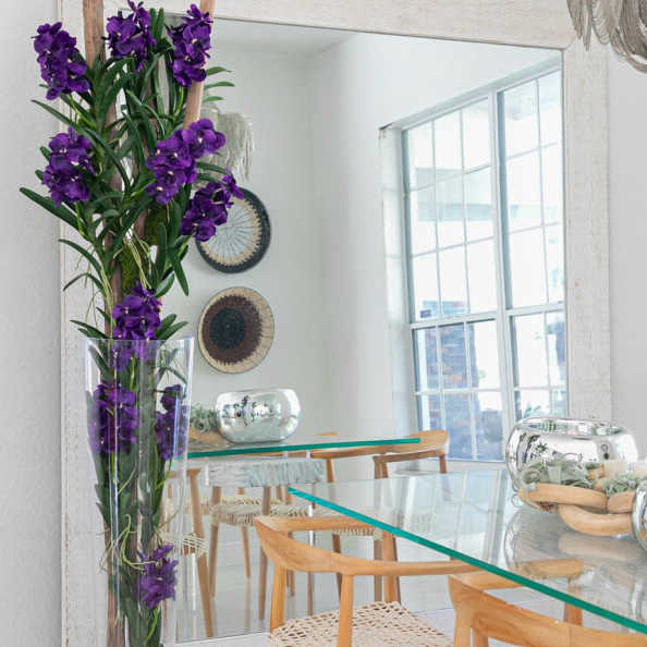 púrpura vanda orquídeas y flotante madera dentro un cónico vidrio cilindro.