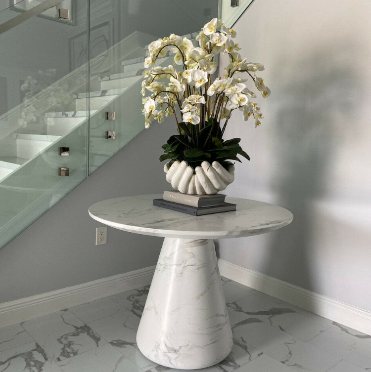 blanco phalaenopsis orquídeas en un abiertas manos escultórico jarrón