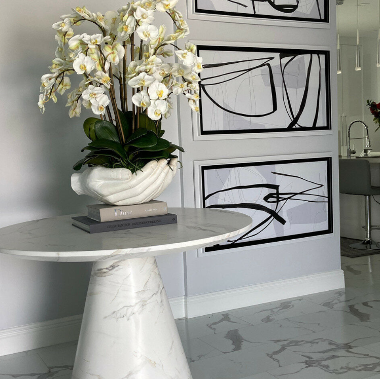 blanco phalaenopsis orquídeas en un abiertas manos escultórico jarrón